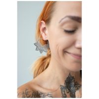 Nahaufnahme einer Frau mit Abey Hoops Ohrringen, die ein stilvolles Blattdesign zeigen