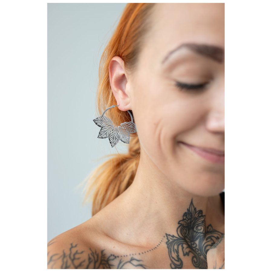 Nahaufnahme einer Frau mit Abey Hoops Ohrringen, die ein stilvolles Blattdesign zeigen
