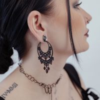 Schwarze barocke Ohrringe aus Chirurgenstahl am Ohr einer Frau, seitliches Profil