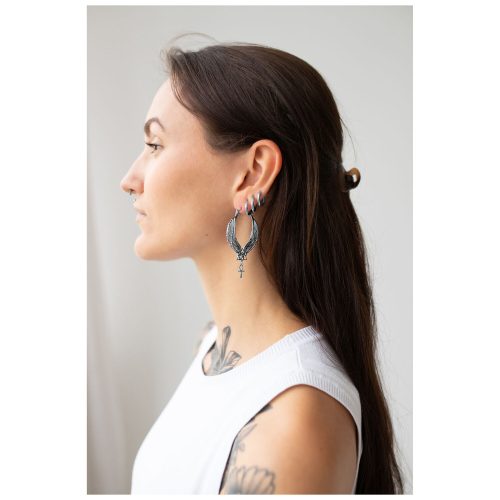 Frau mit langen dunklen Haaren trägt große silberne Cleopatra Hoops Ohrringe