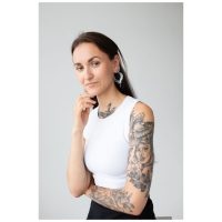 Frau mit Cleopatra Hoops Ohrringen in Silber und Gold auf neutralem Hintergrund
