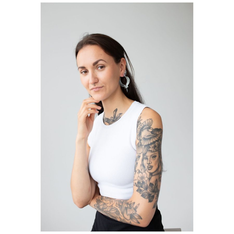 Frau mit Cleopatra Hoops Ohrringen in Silber und Gold auf neutralem Hintergrund