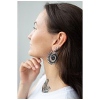 Frau mit silbernen und goldenen Floral Nautilus Hoops vor neutralem Hintergrund