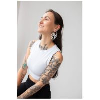 Frau mit langen Haaren trägt auffällige Thunderflash Eye Hoops, weißes Top