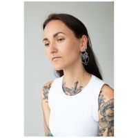 Frau mit langen Haaren trägt silberne Dahlia Hoops Ohrringe vor grauem Hintergrund