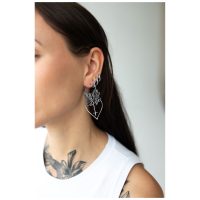 Frau mit Dahlia Hoops Ohrringen in Schwarz und Silber, seitliches Porträt