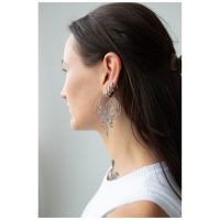 Junge Frau mit langen Haaren trägt große, schwarze Oracle Hoops Ohrringe seitlich im Profil