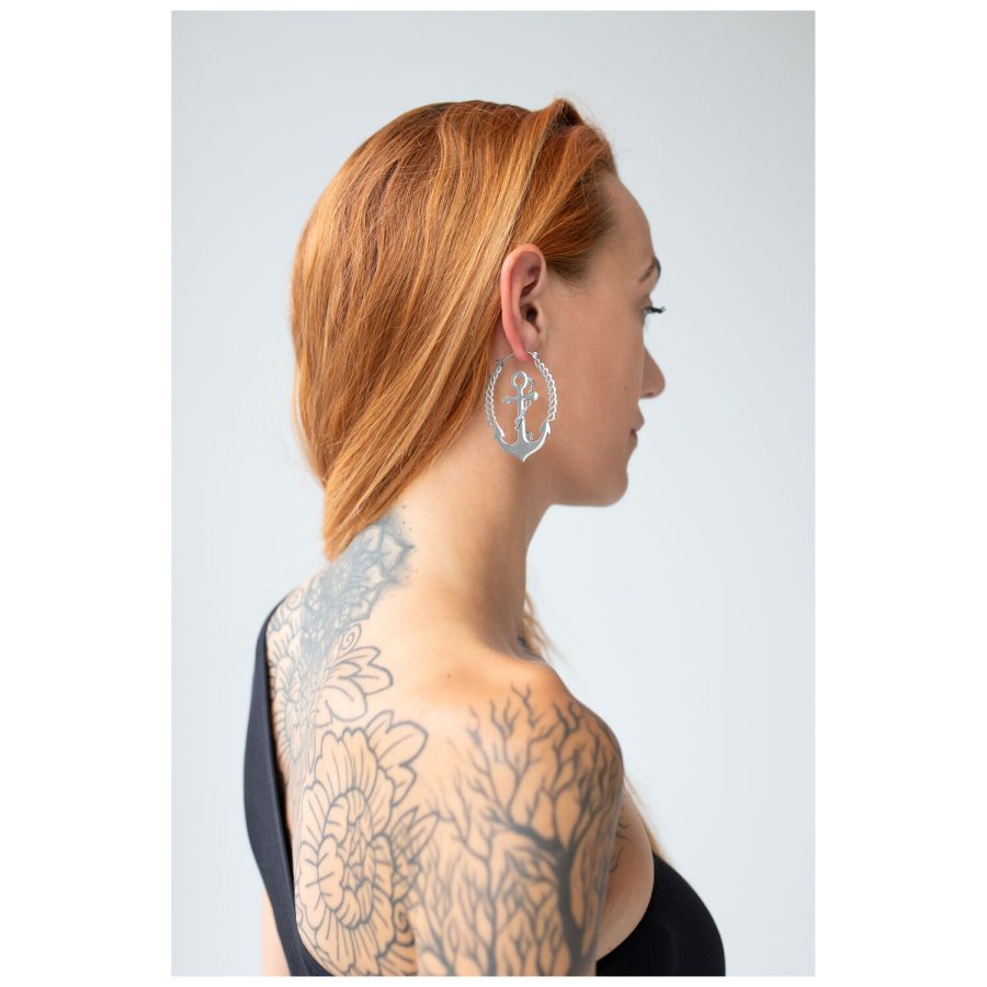 Frau mit roten Haaren trägt silberne Chain Anchor Hoops vor hellem Hintergrund