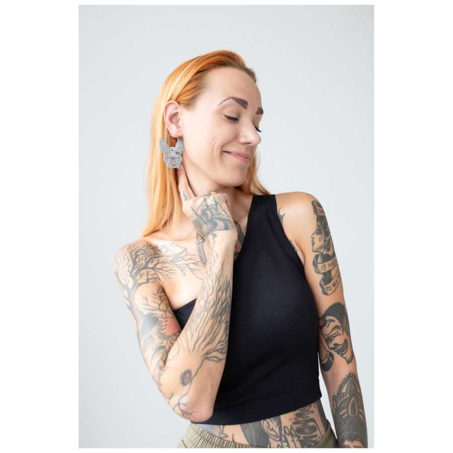 Frau mit Tattoos trägt große Bulldog Hoops Ohrringe