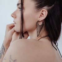 Schwarze Prisma Hoops Ohrringe an einer Frau mit braunem Haar, seitlich fotografiert