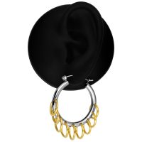 Silberne Creole mit mehreren goldenen Ringen auf schwarzem Hintergrund