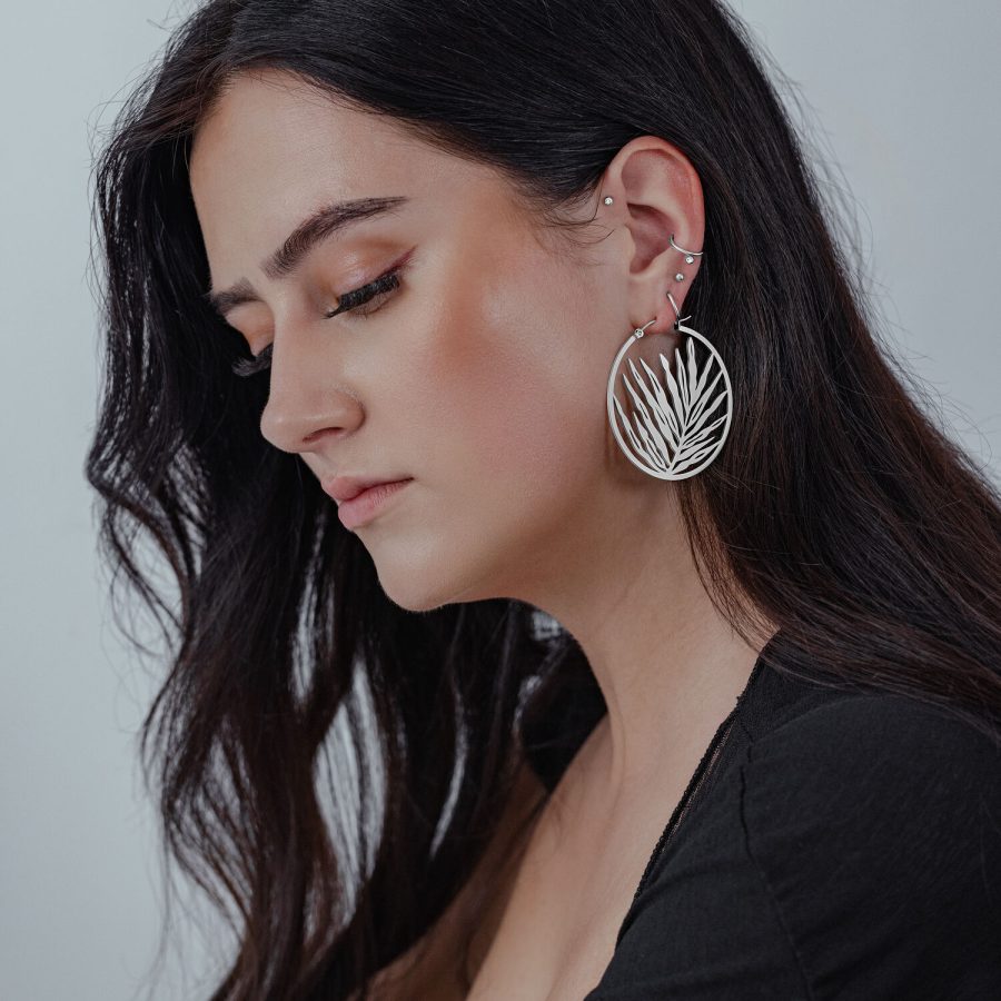 Silberne Noble Leaf Hoops Ohrringe an Frau mit langem, dunklem Haar