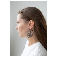 Frau mit langen Haaren trägt große schwarze Lotus Hoops Ohrringe