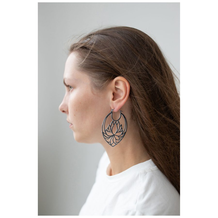 Frau mit langen Haaren trägt große schwarze Lotus Hoops Ohrringe