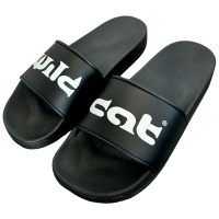 Schwarze PVC-Slides mit weißem Wildcat-Logo auf neutralem Hintergrund