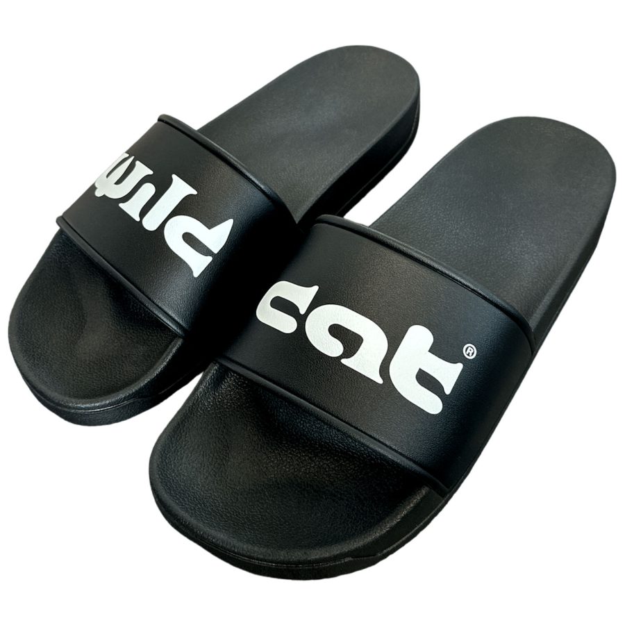 Schwarze PVC-Slides mit weißem Wildcat-Logo auf neutralem Hintergrund