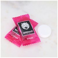 Zwei pinke Wildcat Zitronen-Dextrosetabletten auf Marmorhintergrund