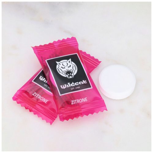 Zwei pinke Wildcat Zitronen-Dextrosetabletten auf Marmorhintergrund