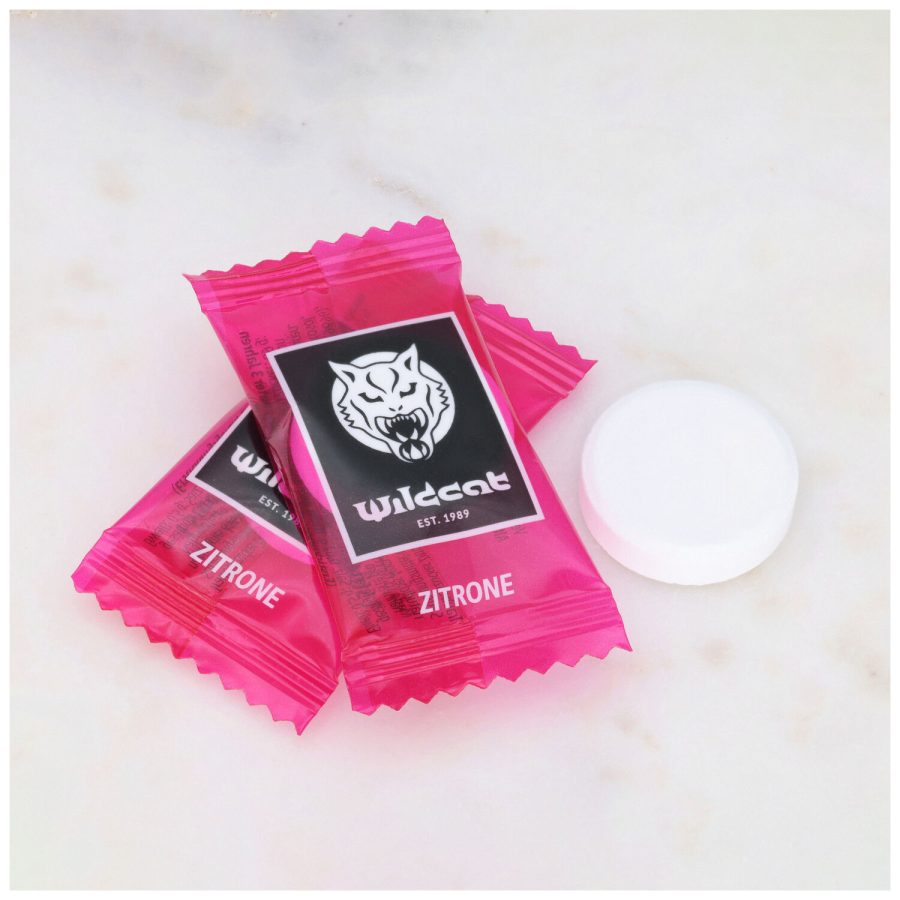 Zwei pinke Wildcat Zitronen-Dextrosetabletten auf Marmorhintergrund