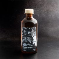 Braune Glasflasche mit Wildcat Design auf dunklem Hintergrund