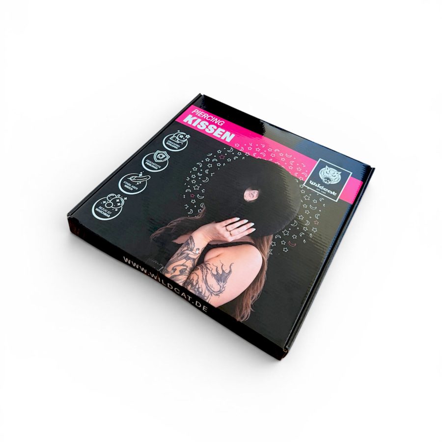 Schwarze Verpackung eines Wildcat Piercingkissens mit pinkem Logo und Grafiken.