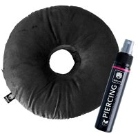 Rundes, schwarzes Piercingkissen aus Polyester mit zentralem Loch, daneben eine Piercing-Pflegesprayflasche auf weißem Hintergrund
