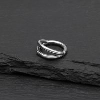 Silberner doppelreihiger Clicker Ring aus Titan auf schwarzem Hintergrund