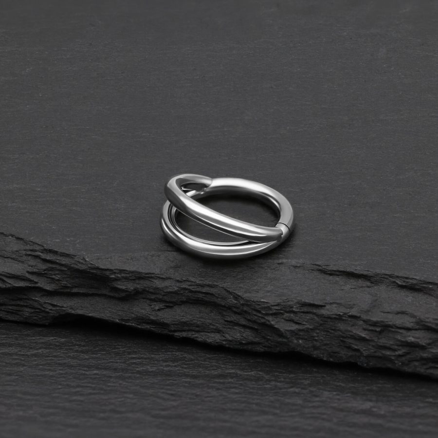 Silberner doppelreihiger Clicker Ring aus Titan auf schwarzem Hintergrund