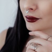 Frau mit silbernem Septum Clicker und roten Lippen