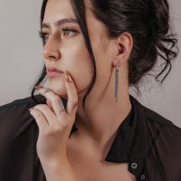 Frau mit elegantem Pearl Clicker Piercing in Silber am Ohr, schwarzes Haar