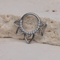 Silberner Septum Clicker mit klaren Kristallen auf hellem Stein