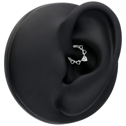 Silberner Septum Clicker mit herzförmigen Kristallen auf schwarzem Modell-Ohr
