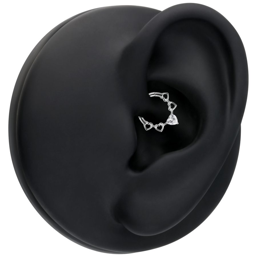 Silberner Septum Clicker mit herzförmigen Kristallen auf schwarzem Modell-Ohr