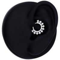 Silberner Kristall Septum Clicker an einem schwarzen Modell-Ohr auf weißem Hintergrund