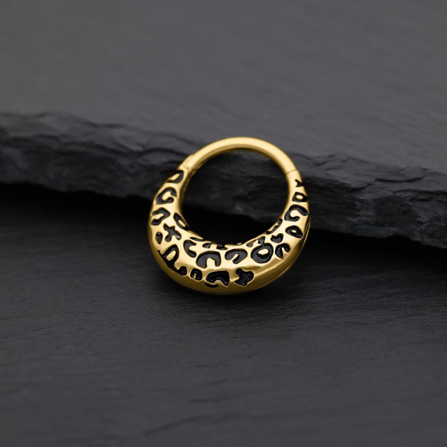 Goldener Septum Clicker mit Leopardenmuster auf schwarzem Hintergrund
