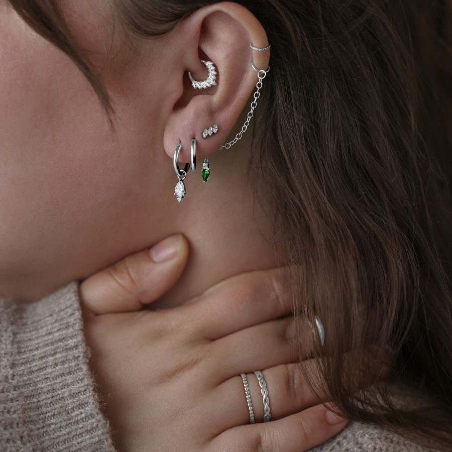 Frau mit mehreren silbernen Piercings am Ohr, darunter ein Gracia Aufsatz