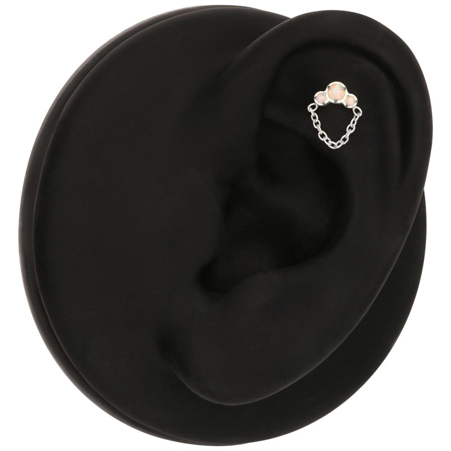 Ohrpiercing mit Opal und Kette auf schwarzem Hintergrund