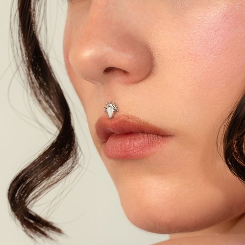 Nahaufnahme eines Nasenpiercings mit weißgoldenem Opal Sonnstrahlen Aufsatz