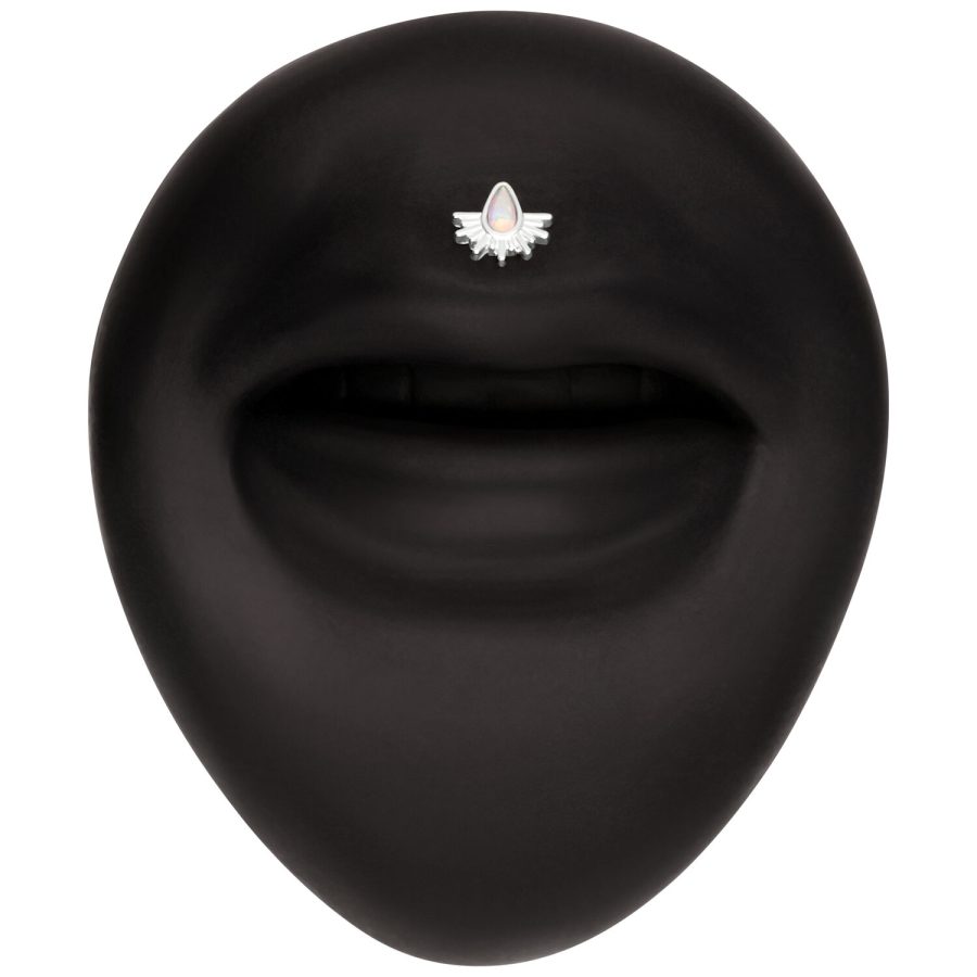 Schwarzer Hintergrund mit einem kleinen, weißen Aufsatz in Form von Sonnenstrahlen, verziert mit einem opalisierenden Stein.