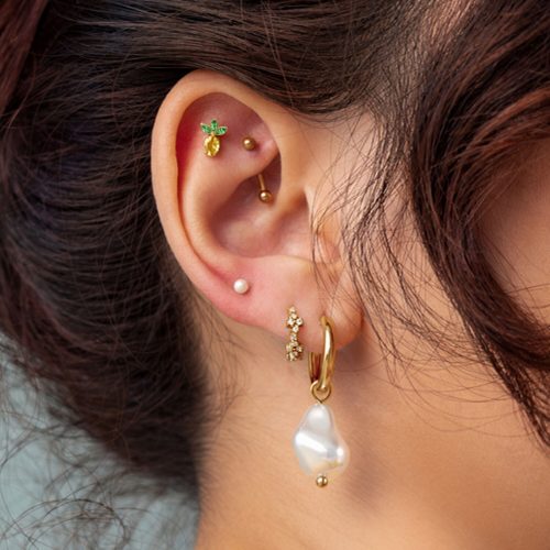 Ohrenpiercing mit goldenem Ananas-Aufsatz und Perlenanhänger