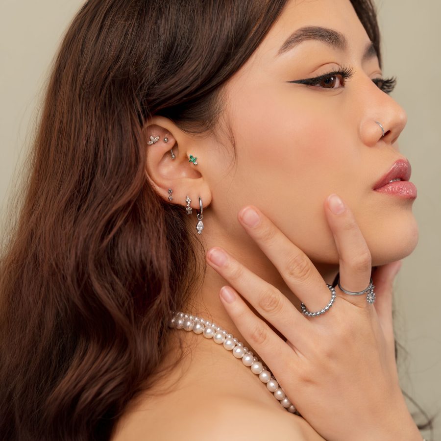 Frau mit mehreren silbernen Piercings, einschließlich Cactus Push Fit, seitlich fotografiert