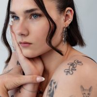Frau mit mehreren Ohrpiercings, darunter ein silberner Helix Aufsatz, Nahaufnahme