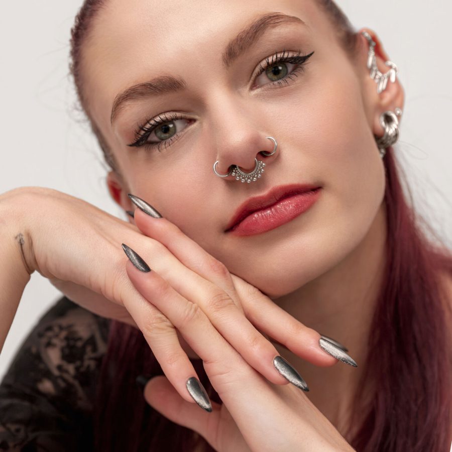 Frau mit rotem Haar trägt einen silbernen Septum Clicker mit Kugelverzierung